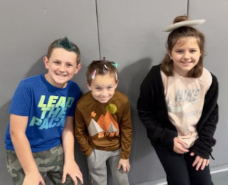 Three Mayflower students posing together indoors