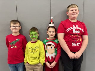 Four Mayflower students posing together in holiday clothing